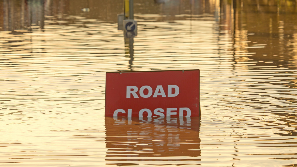 flooding surrounding a closed road sign